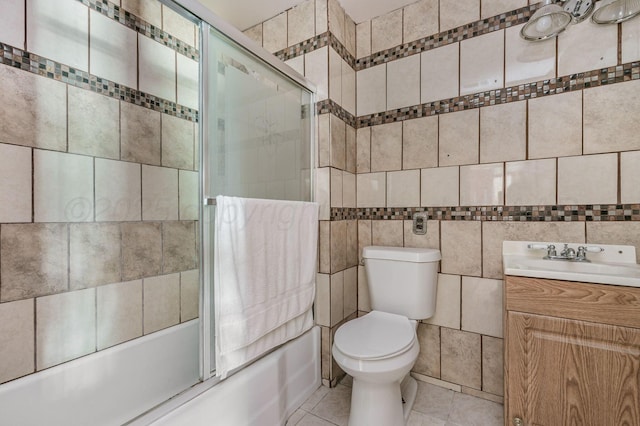 102 S Sumner St, Pampa, TX 79065 - full bathroom featuring tile walls, shower / bath combination with glass door, tile patterned flooring, vanity, and toilet
