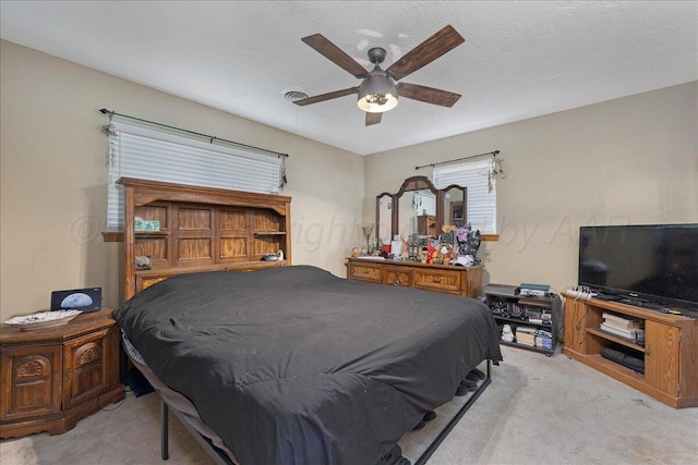 bedroom featuring light carpet and ceiling fan