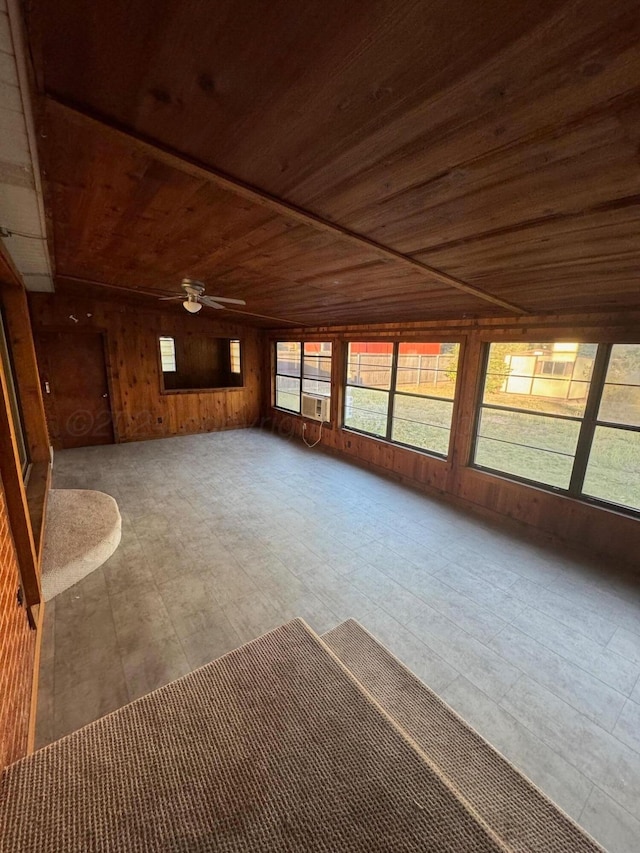 interior space featuring ceiling fan, wood walls, wood ceiling, and vaulted ceiling