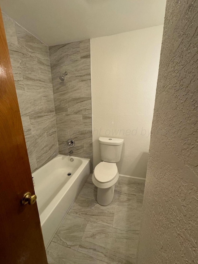 bathroom with tub / shower combination and toilet