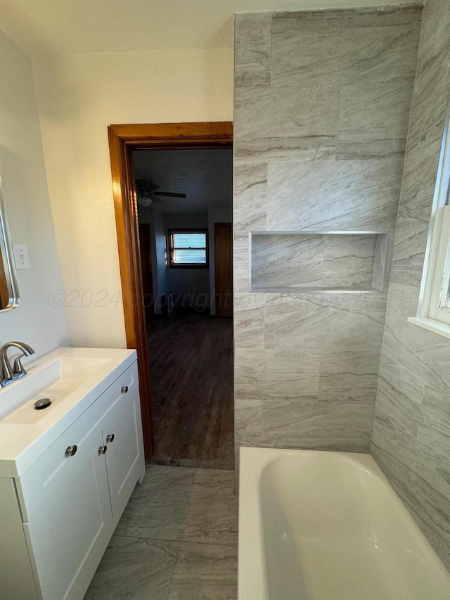 bathroom featuring a bath, wood-type flooring, vanity, and ceiling fan