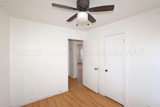unfurnished bedroom featuring a closet, light wood-type flooring, baseboards, and ceiling fan