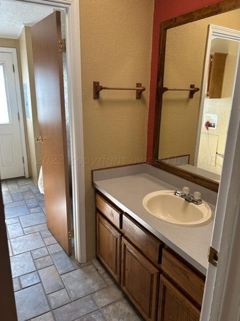 bathroom with a textured ceiling and vanity