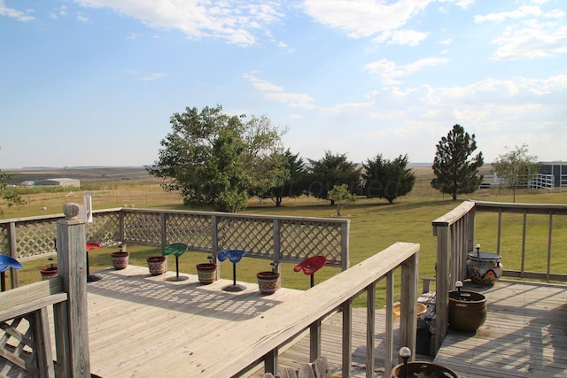 wooden terrace with a rural view and a yard