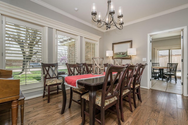 7826 Tarrytown Ave, Amarillo, TX 79121 - dining space with an inviting chandelier, baseboards, crown molding, and hardwood / wood-style floors