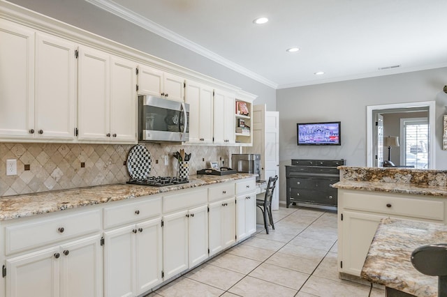 7826 Tarrytown Ave, Amarillo, TX 79121 - kitchen with visible vents, decorative backsplash, light tile patterned flooring, white cabinets, and stainless steel appliances