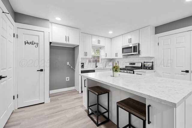 1108 N Taylor St, Amarillo, TX 79107 - kitchen featuring appliances with stainless steel finishes, recessed lighting, white cabinetry, backsplash, and a center island