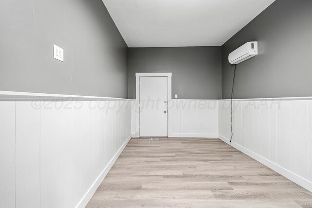 1108 N Taylor St, Amarillo, TX 79107 - unfurnished room featuring a wall mounted AC, light wood-type flooring, a wainscoted wall, and a decorative wall
