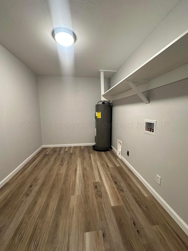 clothes washing area featuring electric water heater, hardwood / wood-style flooring, hookup for a washing machine, and electric dryer hookup