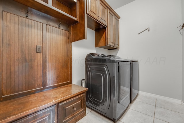 laundry room featuring cabinets, independent washer and dryer, and light tile patterned flooring