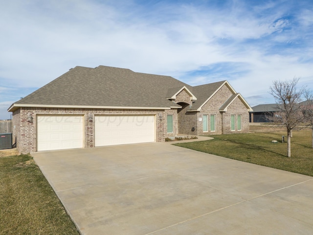 view of front of house with a garage, central AC unit, and a front yard