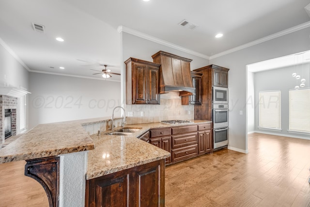 kitchen with a breakfast bar, sink, kitchen peninsula, stainless steel appliances, and backsplash
