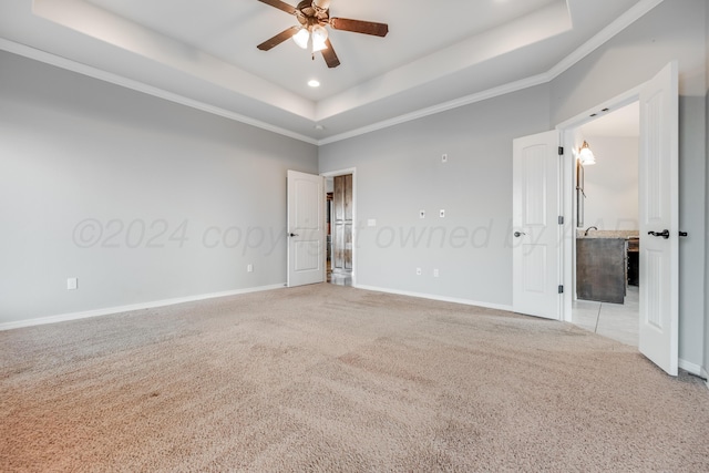 empty room with crown molding, ceiling fan, a towering ceiling, light carpet, and a raised ceiling