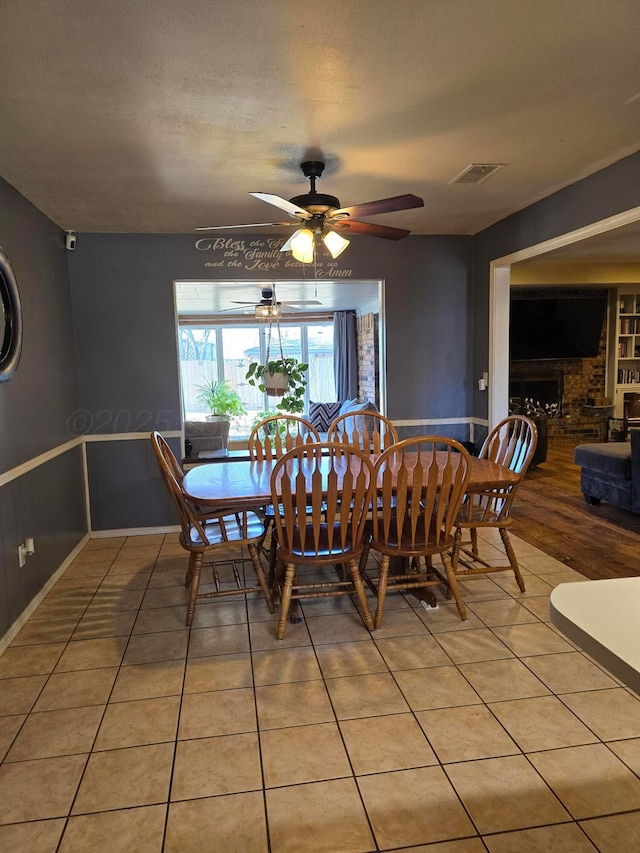 tiled dining area featuring a textured ceiling and ceiling fan