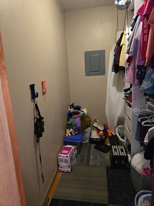 laundry area with electric panel and a textured ceiling