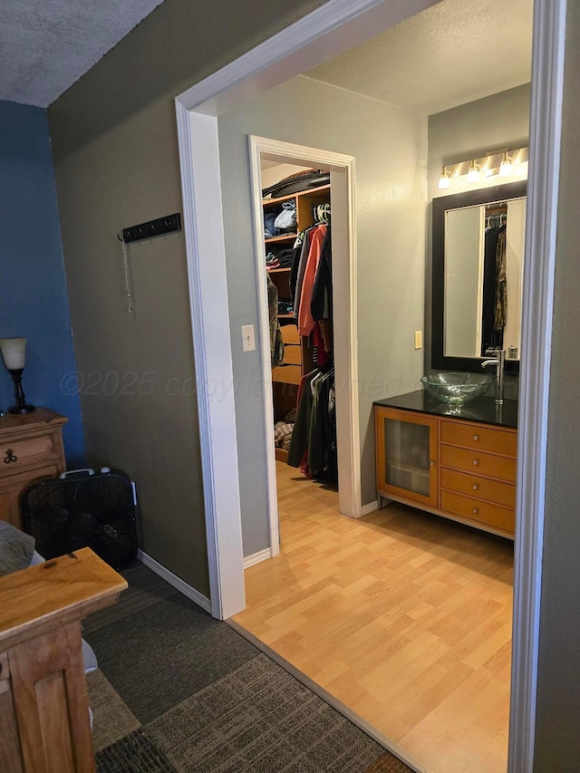 bathroom featuring hardwood / wood-style flooring, vanity, and a textured ceiling