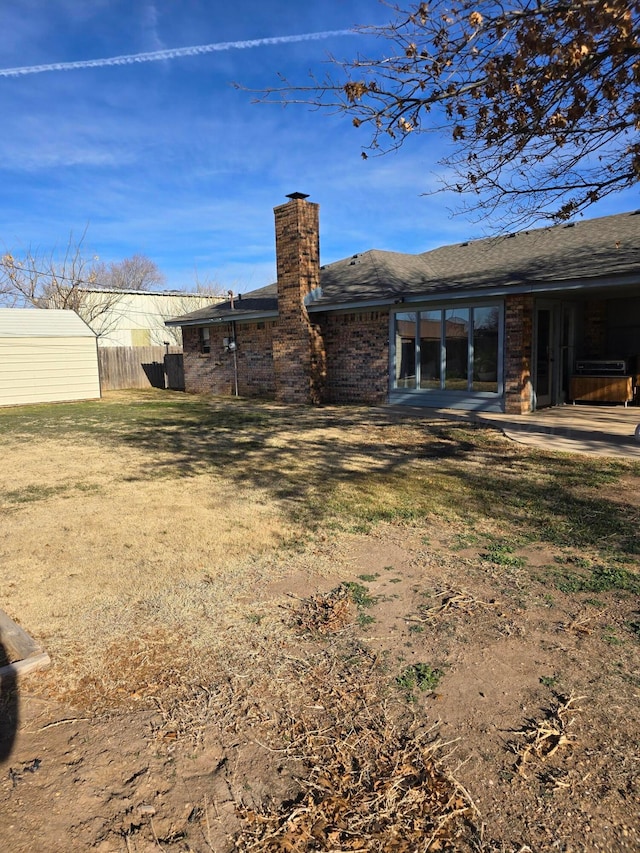 rear view of house with a patio and a lawn