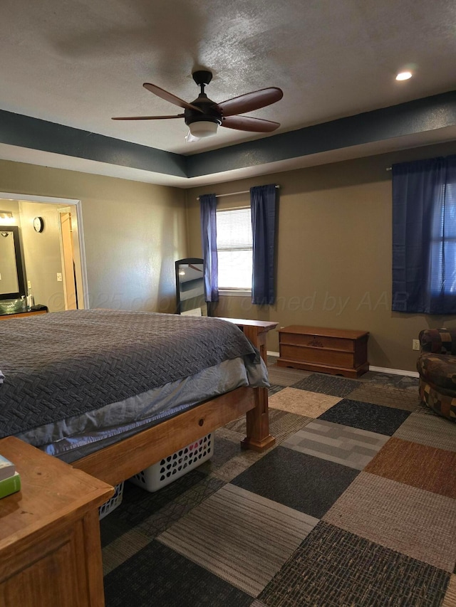 bedroom with ceiling fan and a textured ceiling