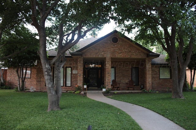 7717 Tripp Ave, Amarillo, TX 79121 - view of front of house featuring a front yard, brick siding, and a porch