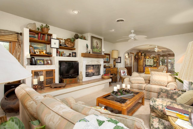 803 N Locust St, Wildorado, TX 79098 - carpeted living area with arched walkways, ceiling fan, and a fireplace