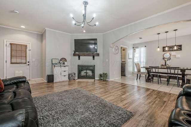 8508 Littlerock Dr, Amarillo, TX 79118 - living room featuring arched walkways, crown molding, wood finished floors, a chandelier, and a fireplace