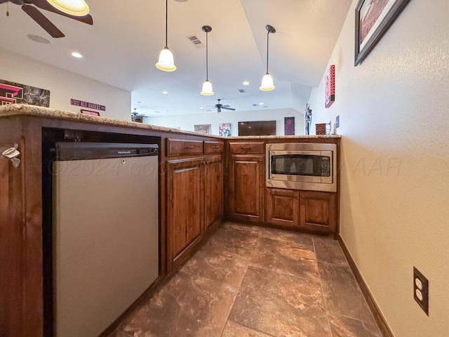 2501 Mackenzie Trl, Amarillo, TX 79124 - kitchen with stainless steel microwave, visible vents, brown cabinetry, refrigerator, and a ceiling fan