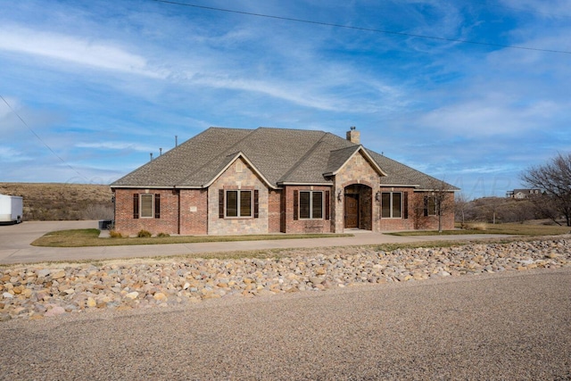 2501 Mackenzie Trl, Amarillo, TX 79124 - french country style house with brick siding, roof with shingles, and a chimney