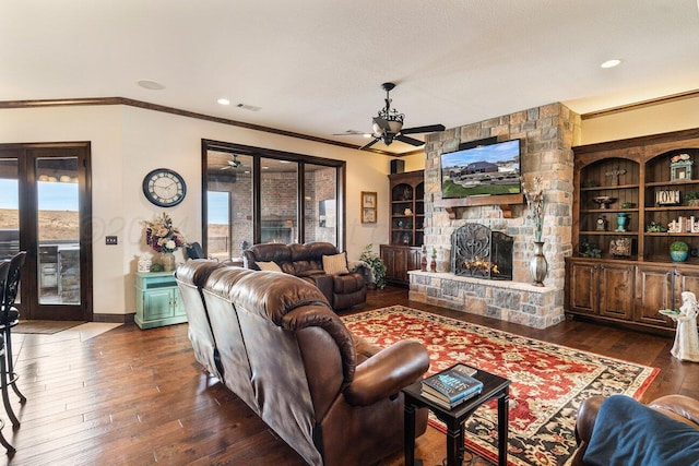 2501 Mackenzie Trl, Amarillo, TX 79124 - living area with a ceiling fan, visible vents, ornamental molding, a stone fireplace, and dark wood-type flooring