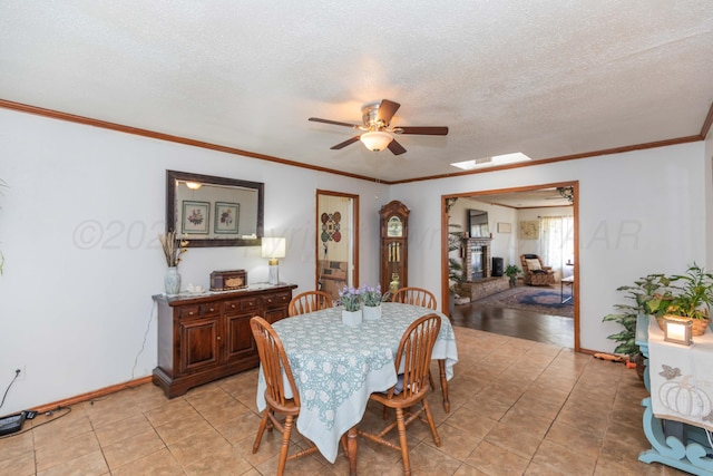 2041 S Travis St, Amarillo, TX 79109 - dining space with ceiling fan, light tile patterned flooring, a textured ceiling, crown molding, and a skylight