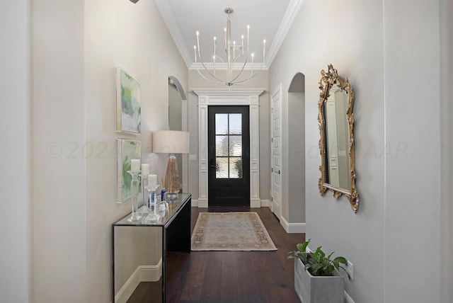 foyer with crown molding, an inviting chandelier, and dark hardwood / wood-style flooring