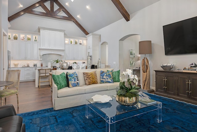 living room featuring dark wood-type flooring, beam ceiling, and high vaulted ceiling