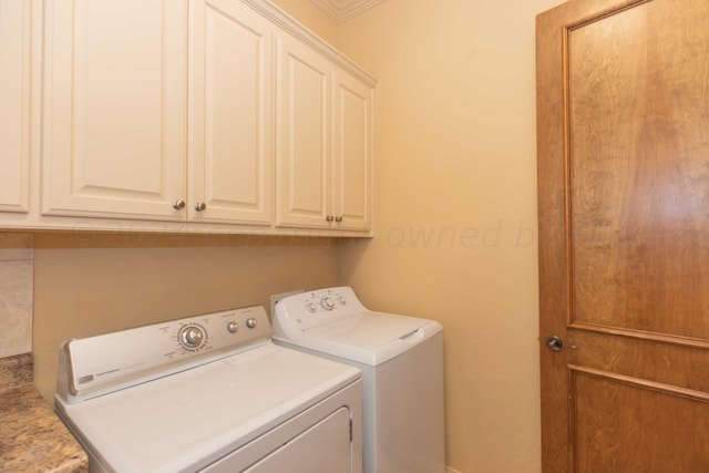 laundry area with washing machine and clothes dryer and cabinets