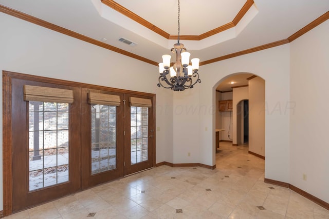 unfurnished dining area with french doors, a tray ceiling, an inviting chandelier, and ornamental molding