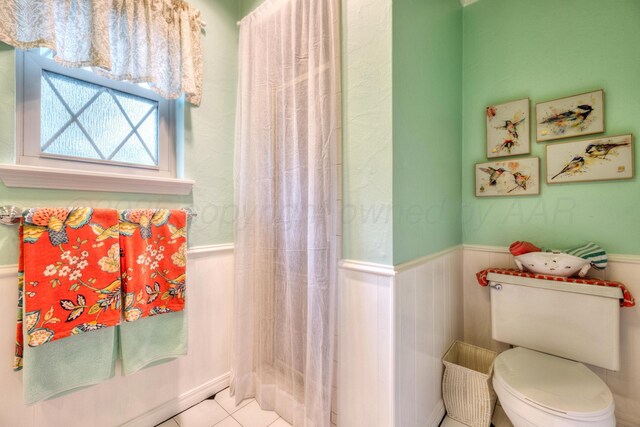 5200 Kingswood Cir, Amarillo, TX 79109 - bathroom featuring wainscoting, a shower with shower curtain, and tile patterned floors