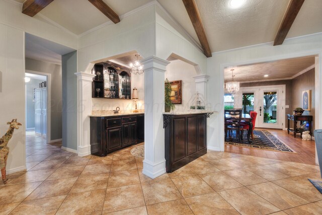 5200 Kingswood Cir, Amarillo, TX 79109 - indoor wet bar featuring a chandelier, light tile patterned flooring, crown molding, and decorative columns