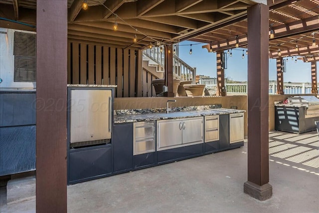view of patio featuring area for grilling, a sink, and stairway
