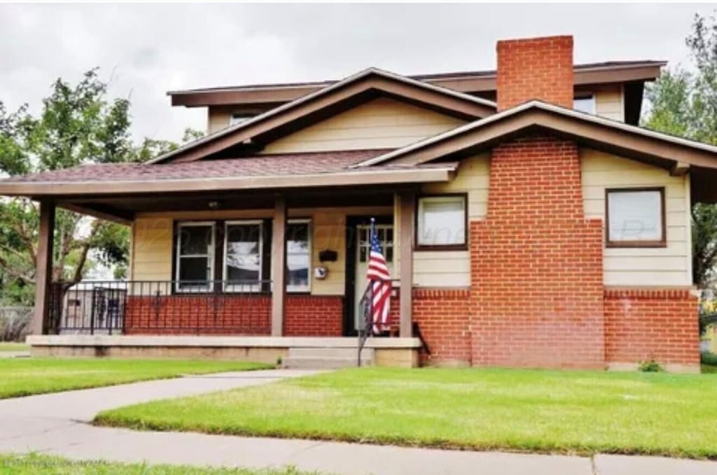 725 N Wilson St, Amarillo, TX 79107 - view of front facade featuring a porch, a front yard, a chimney, and brick siding