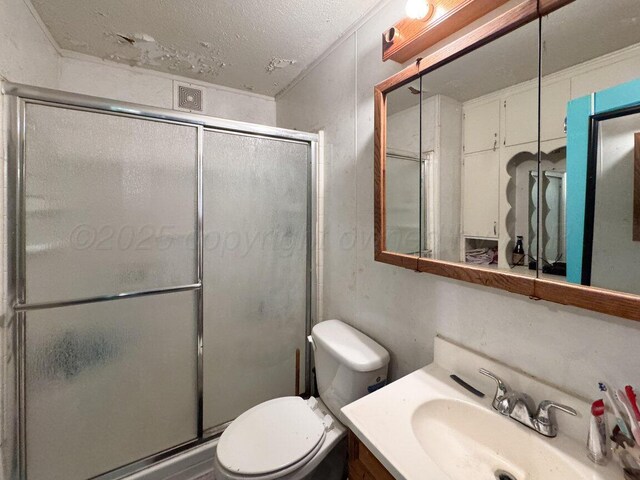 713 N Dwight St, Pampa, TX 79065 - full bathroom with vanity, toilet, a textured ceiling, a shower stall, and visible vents