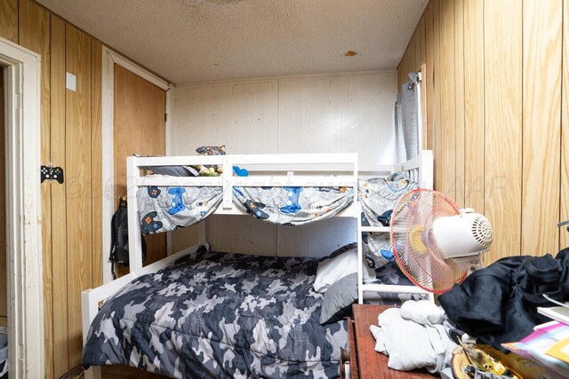 713 N Dwight St, Pampa, TX 79065 - bedroom with wooden walls and a textured ceiling