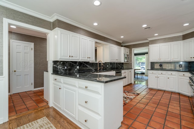 3220 S Travis St, Amarillo, TX 79109 - kitchen with ornamental molding, white cabinets, backsplash, a sink, and recessed lighting
