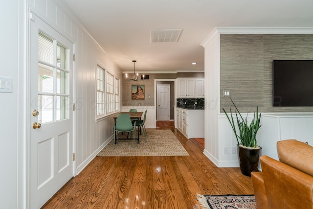 3220 S Travis St, Amarillo, TX 79109 - entrance foyer with wood finished floors, crown molding, and a decorative wall