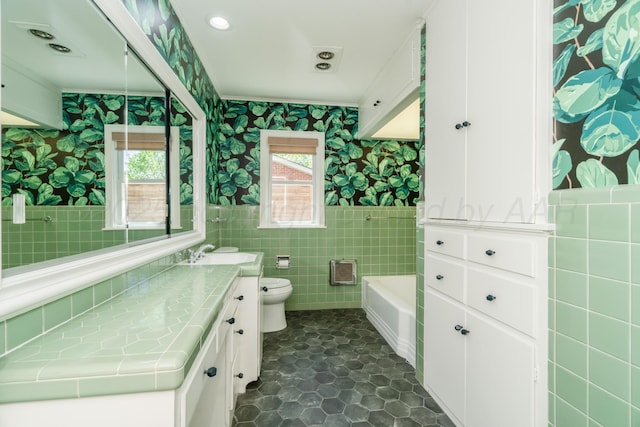 3220 S Travis St, Amarillo, TX 79109 - bathroom with tile walls, wallpapered walls, toilet, tile patterned flooring, and vanity