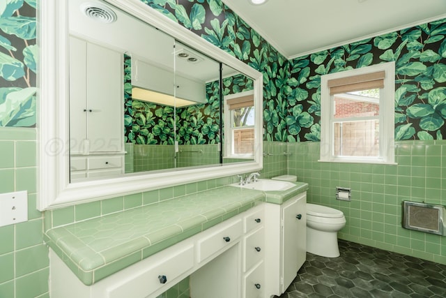 3220 S Travis St, Amarillo, TX 79109 - bathroom featuring wallpapered walls, ornamental molding, tile walls, toilet, and vanity