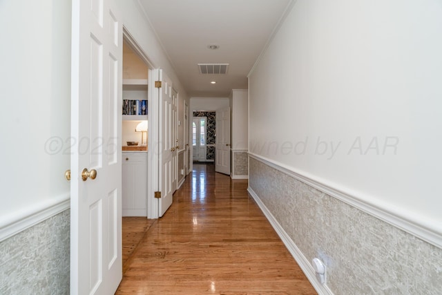 3220 S Travis St, Amarillo, TX 79109 - corridor with light wood finished floors, wainscoting, and crown molding
