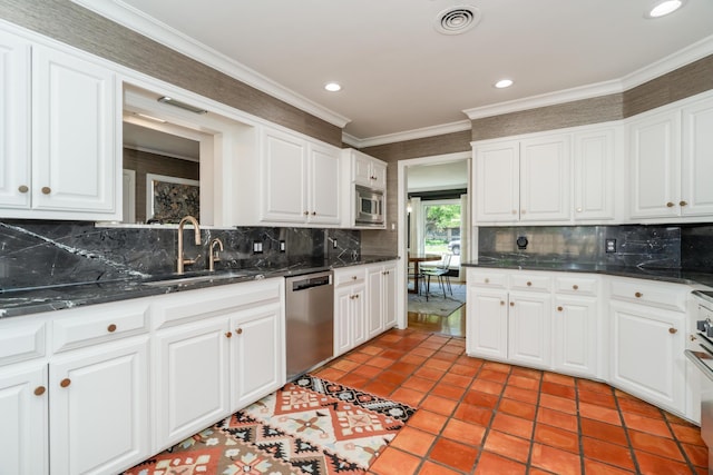3220 S Travis St, Amarillo, TX 79109 - kitchen with appliances with stainless steel finishes, backsplash, a sink, white cabinetry, and recessed lighting