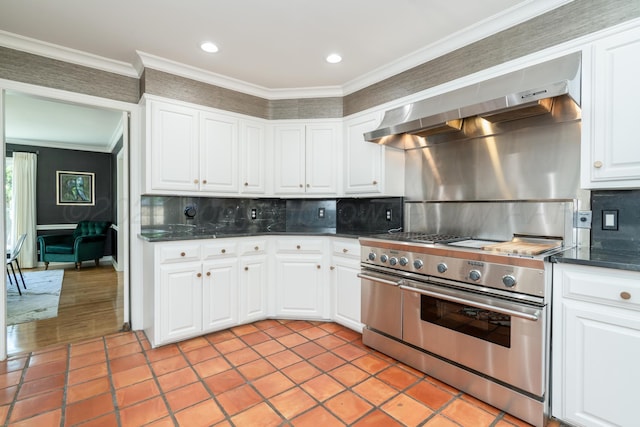 3220 S Travis St, Amarillo, TX 79109 - kitchen with high end stove, wall chimney range hood, dark countertops, tasteful backsplash, and crown molding