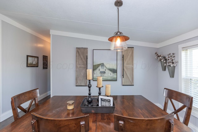 dining space featuring baseboards and wood finished floors