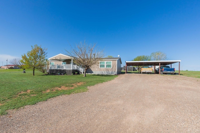 manufactured / mobile home with a front yard, a carport, and dirt driveway