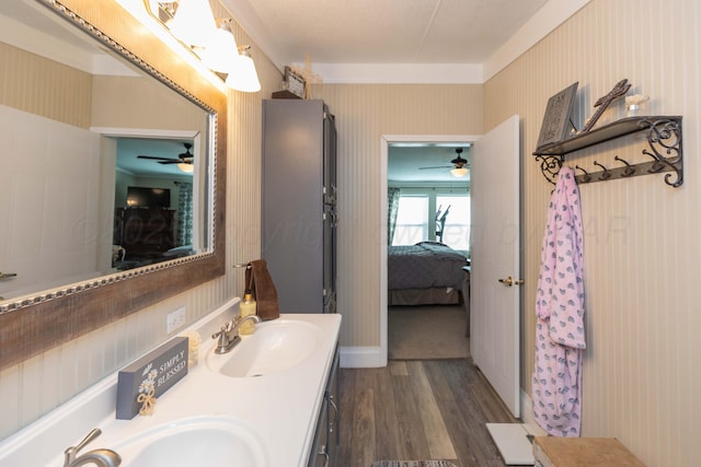 bathroom featuring a sink, ceiling fan, ensuite bath, and wood finished floors