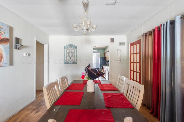 dining space with an inviting chandelier and wood-type flooring